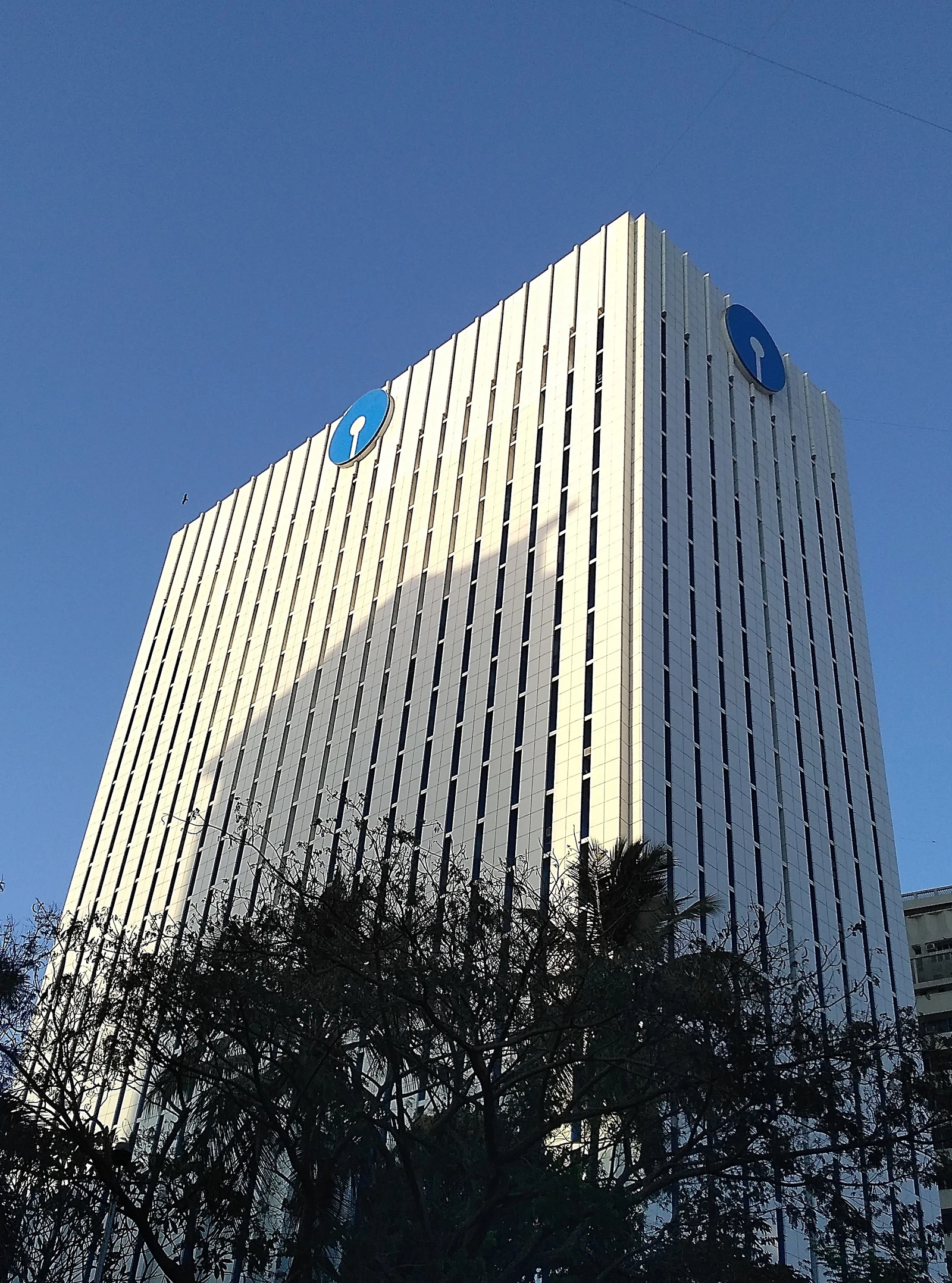 Exterior view of State Bank of India headquarters building against a blue sky.