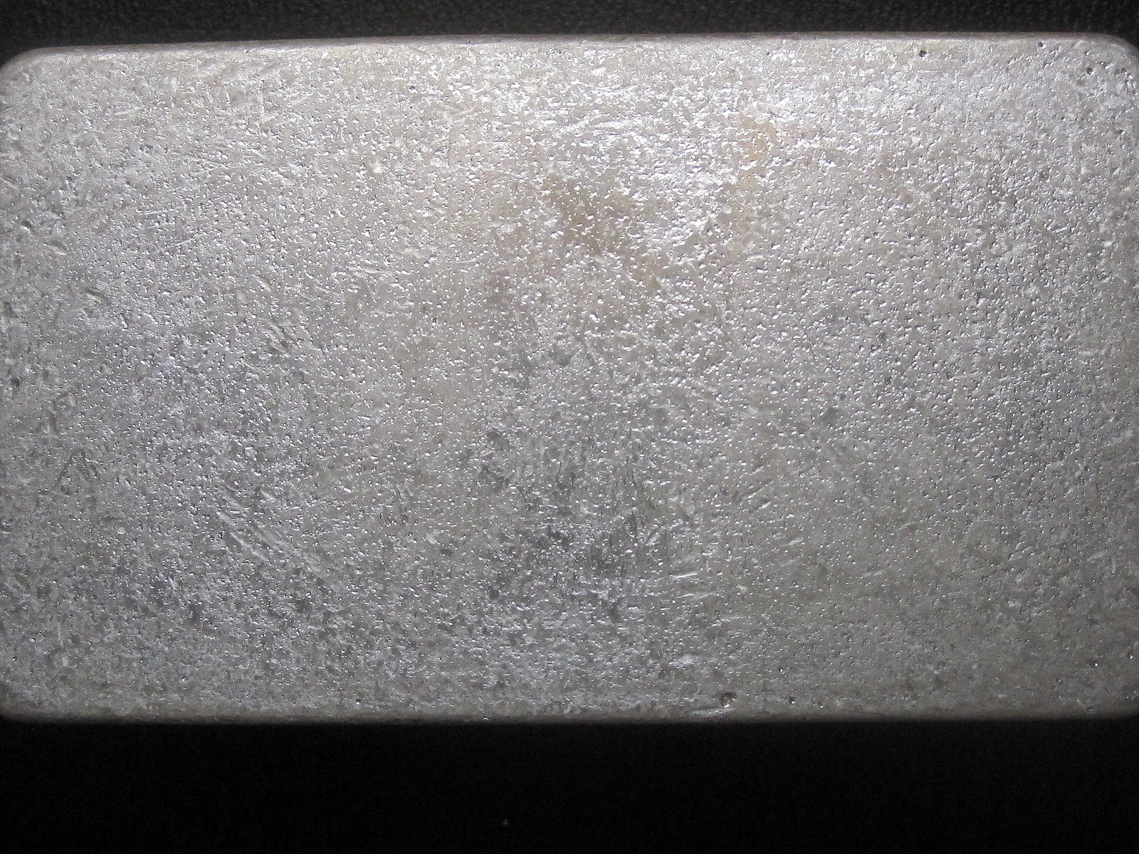 Textured surface of a silver bullion bar, possibly from Rusty's Bullion Bar.