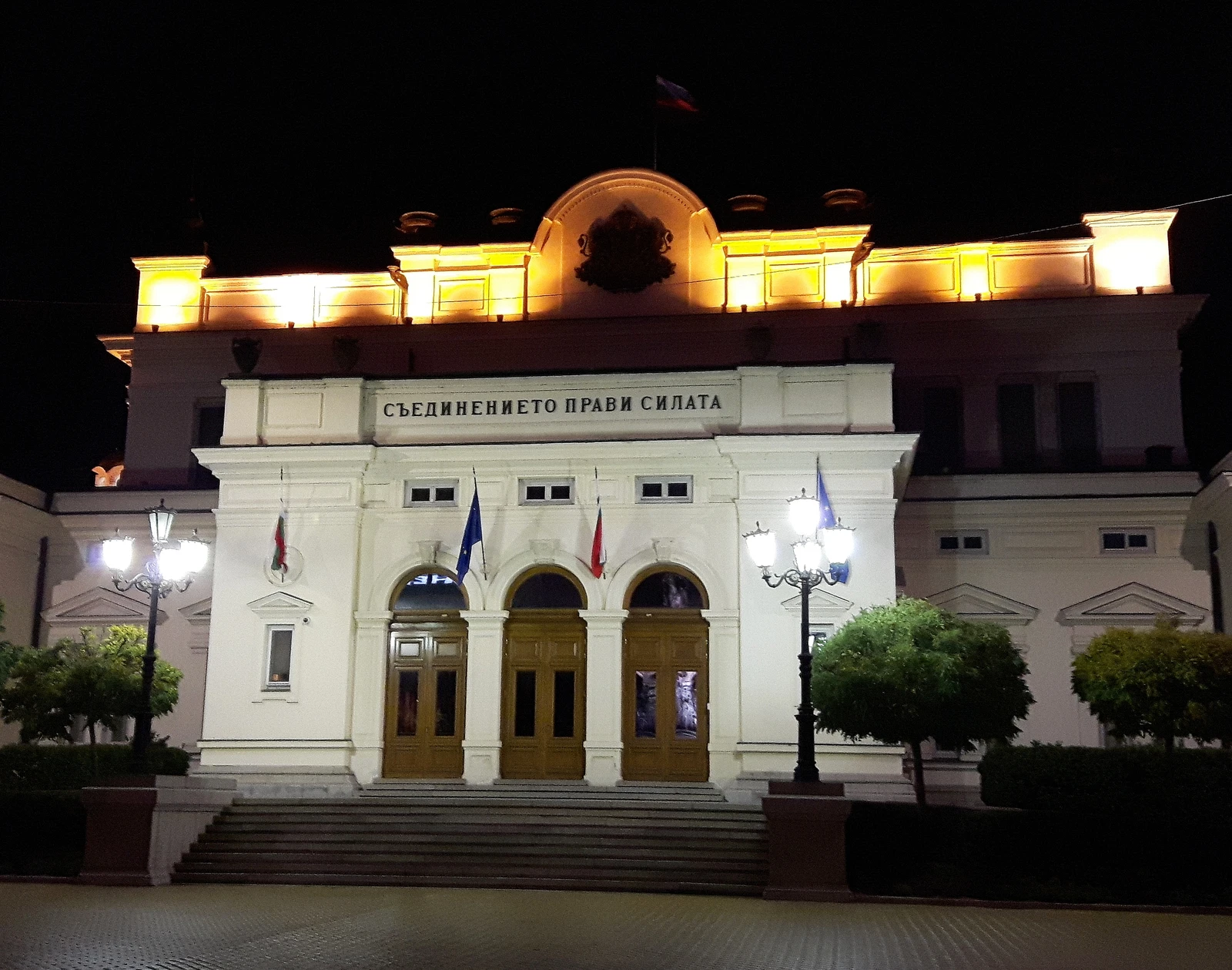 Entrance of the Bulgarian Parliament building in Sofia, illuminated at night.
