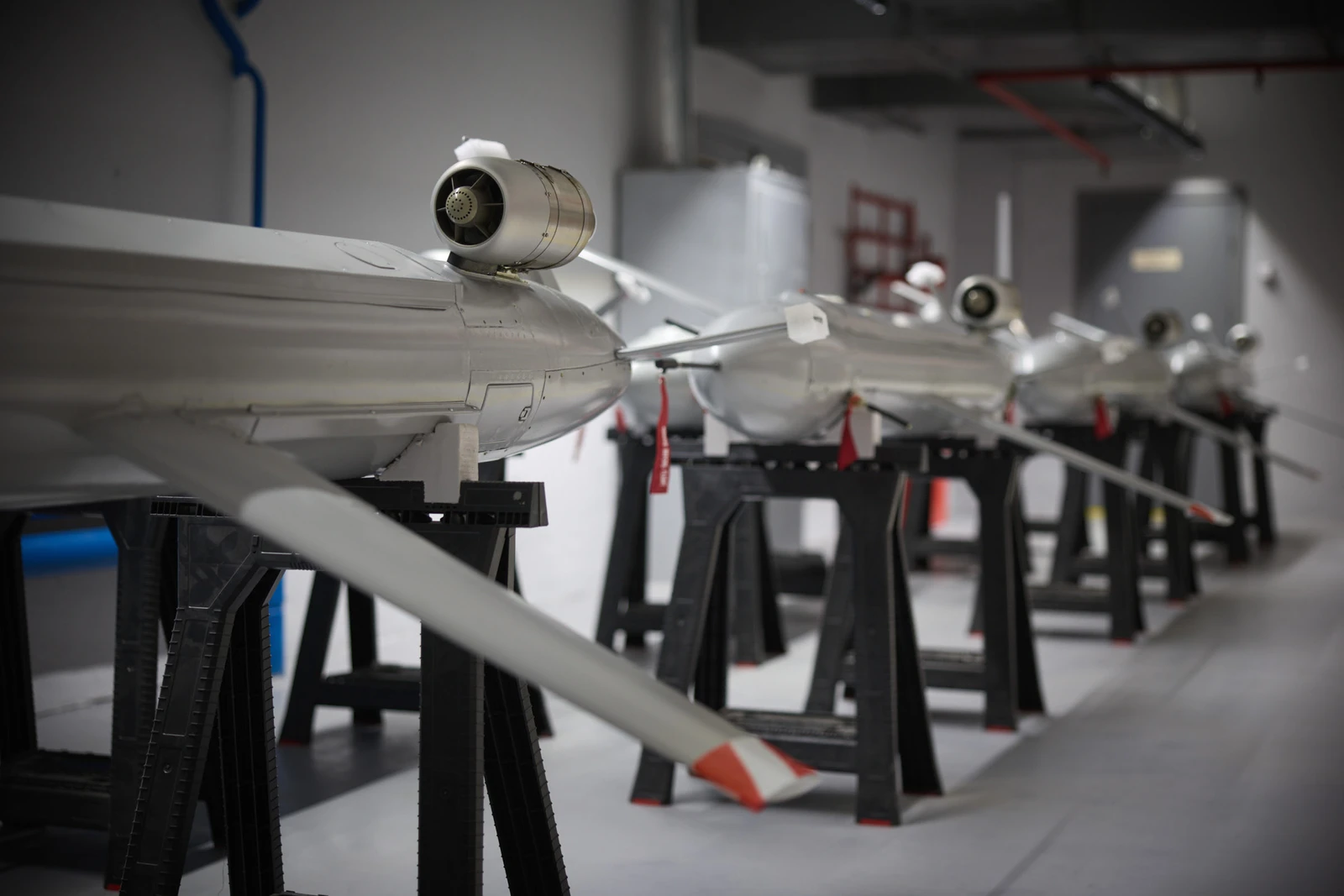 Several long-range weapons resembling drones on display in a production facility.