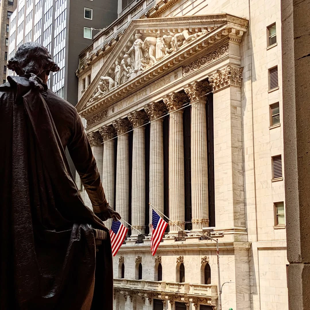 Statue looking at the New York Stock Exchange building on Wall Street.