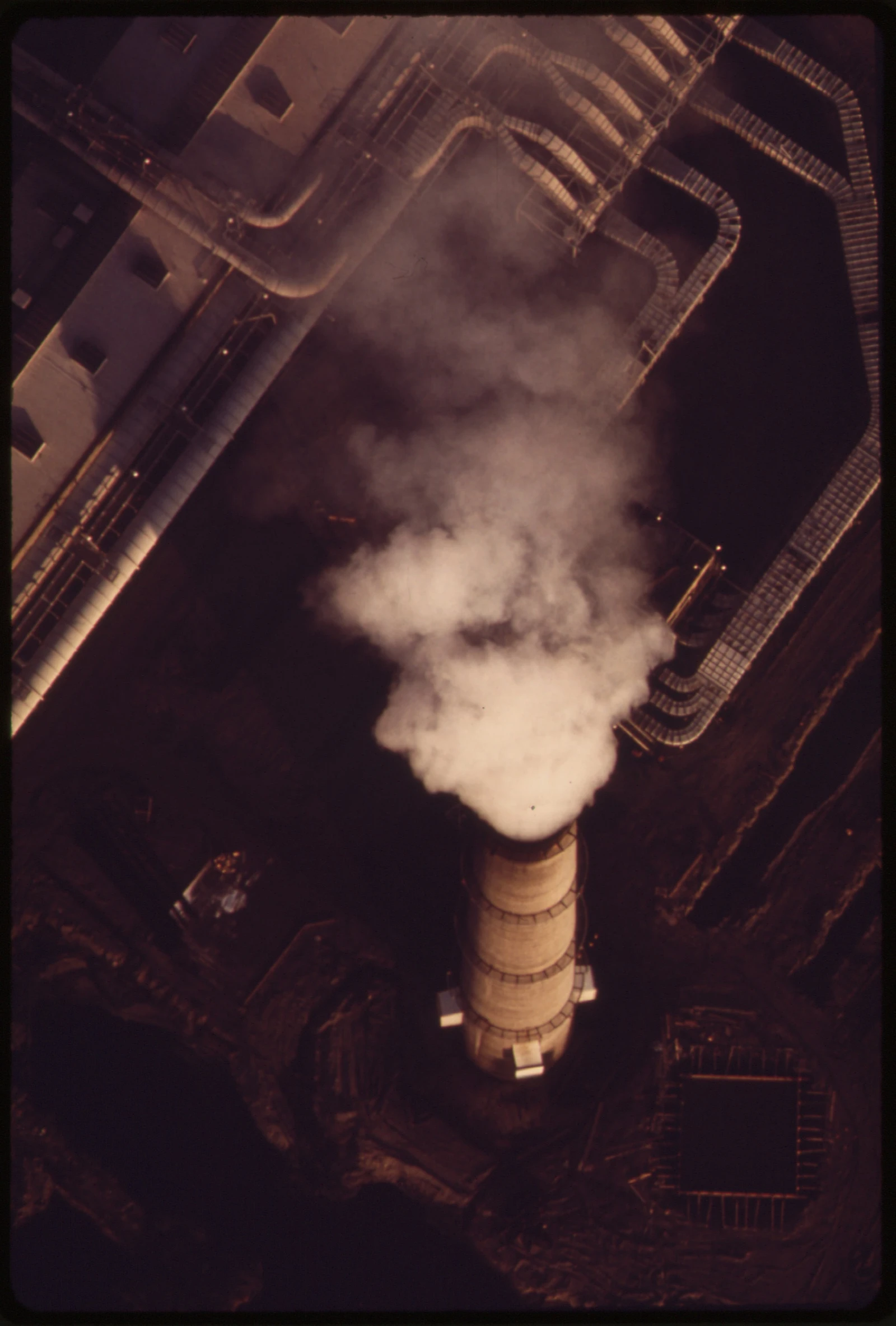 Aerial view of an aluminum smelting plant smoke stack emitting smoke.