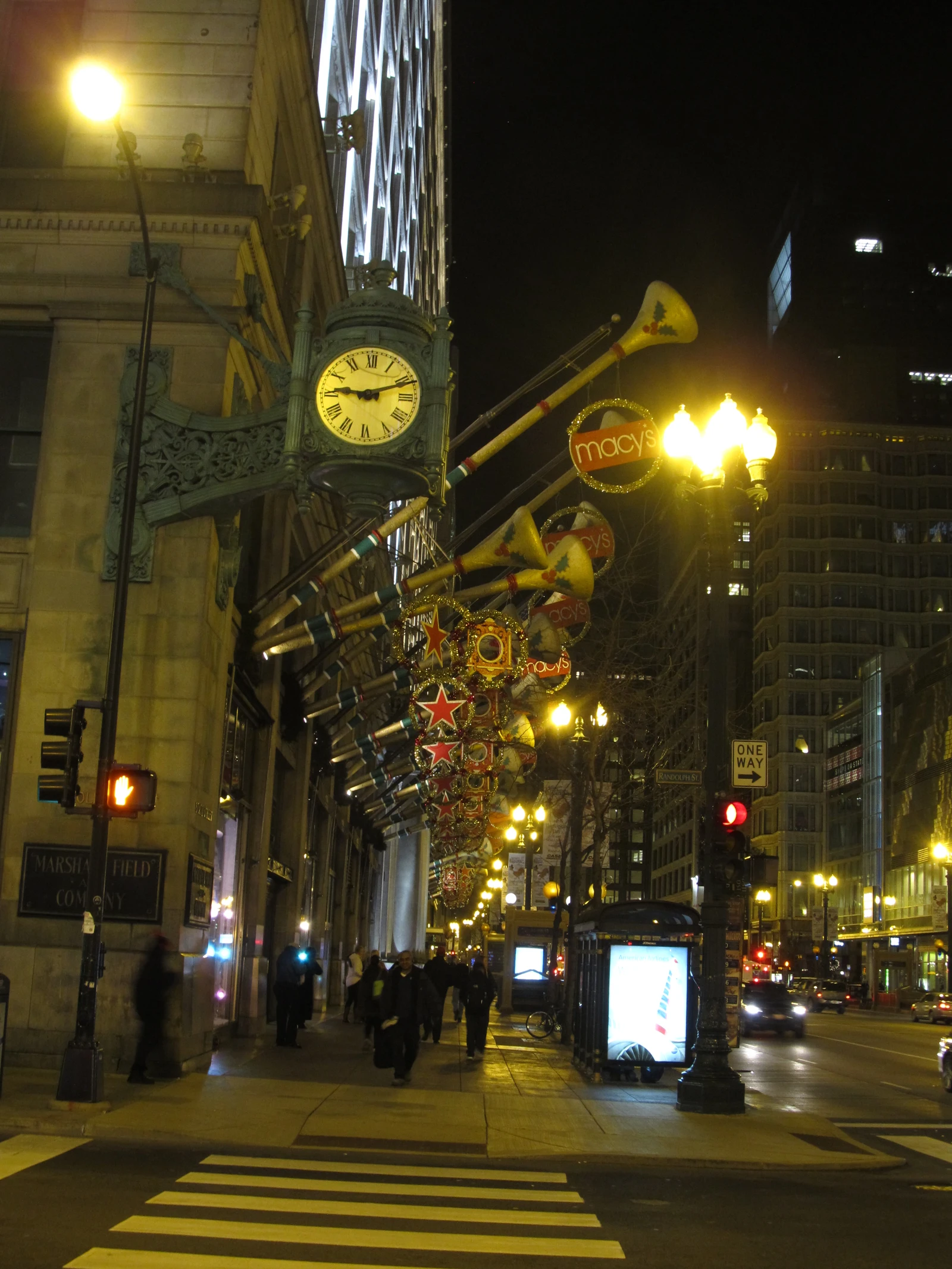 Macy's Christmas decorations and street lights illuminate the Marshall Field building in Chicago at night.