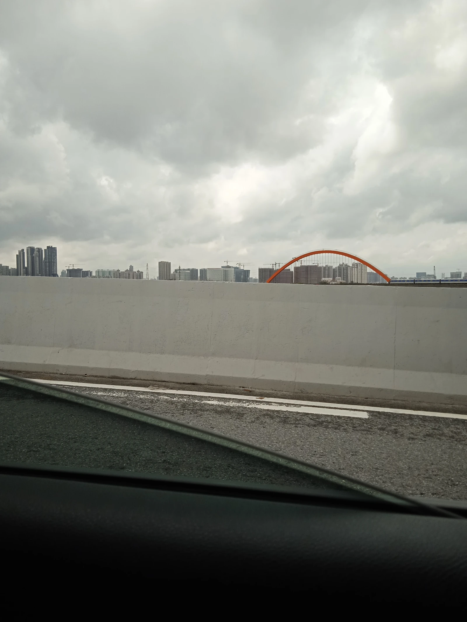 Skyline of Guangzhou's Liwan Datansha district, residential buildings, and an orange arch bridge.