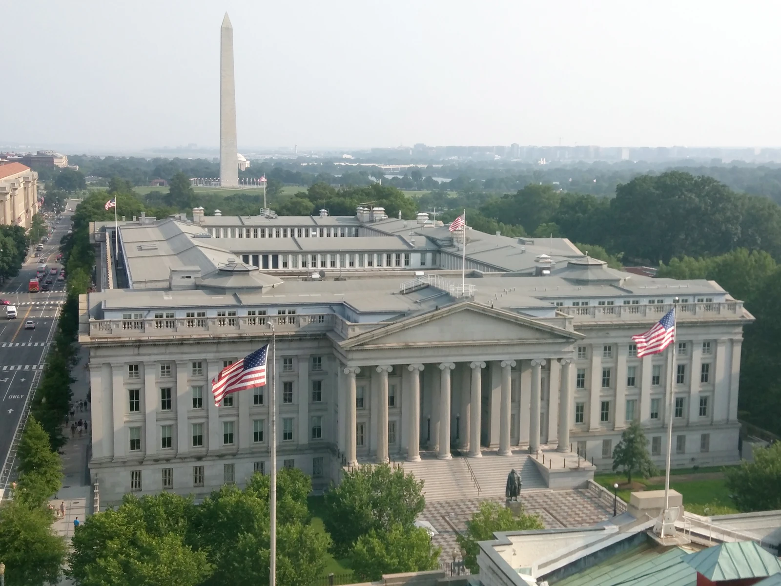 United States Treasury Building, with large columns and an American flag flying prominently.