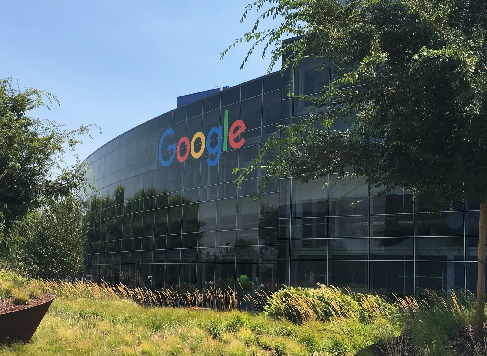 Exterior of Googleplex headquarters building with the Google logo prominently displayed.