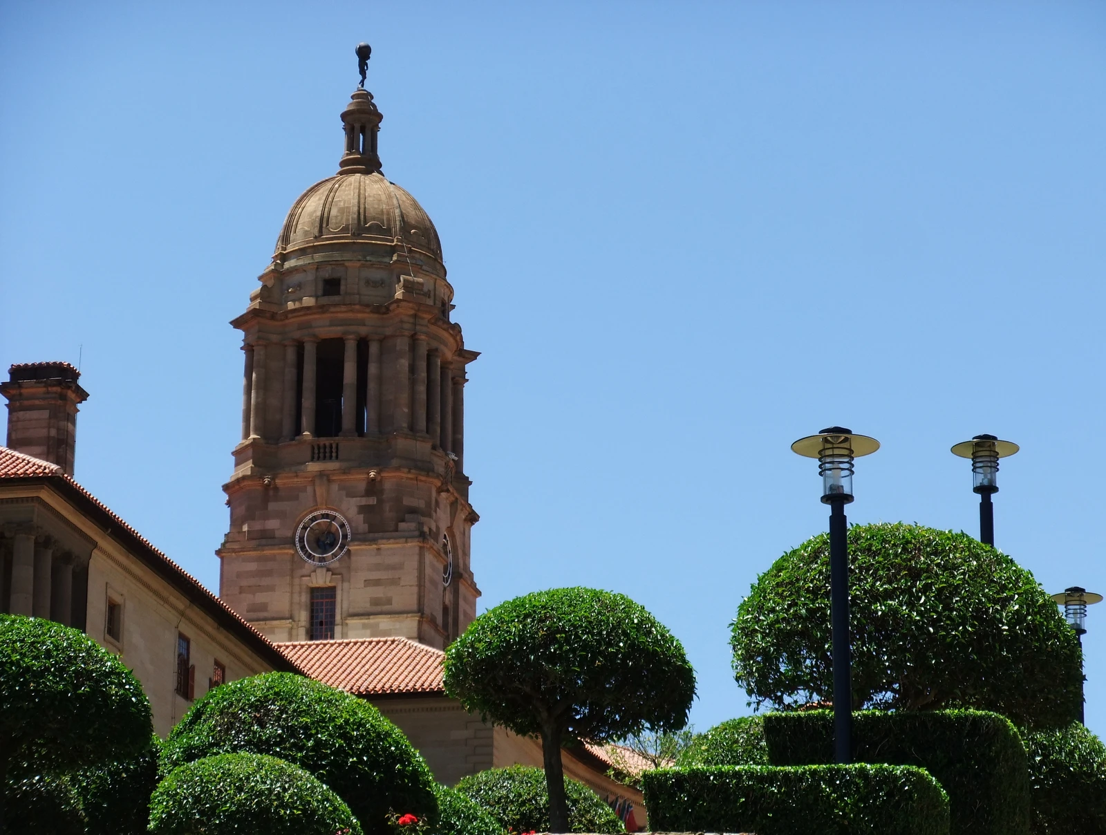 The clock tower of the Union Buildings in Pretoria, South Africa, against a blue sky.