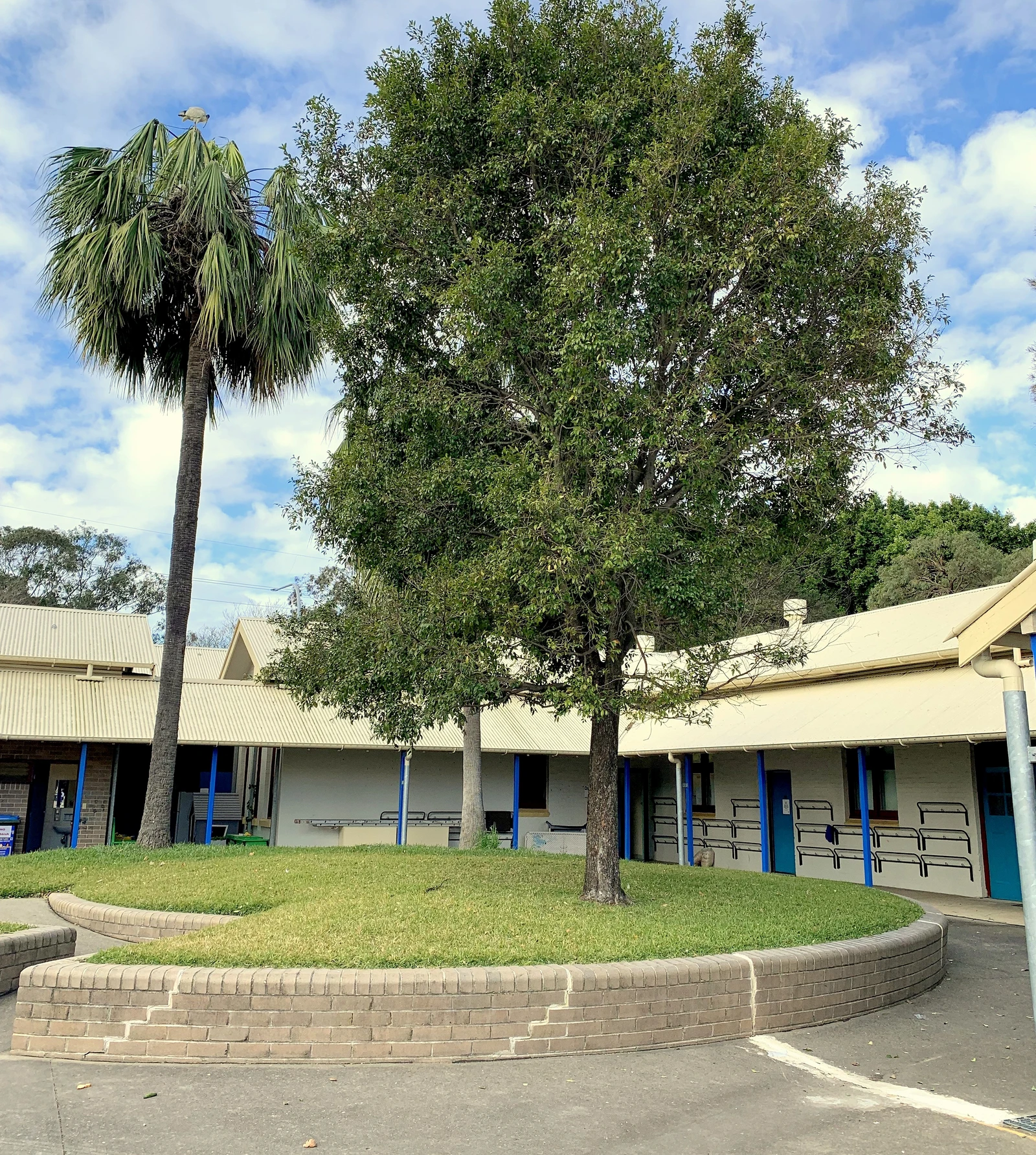 Classroom buildings and grounds at Fairfield Public School under a partly cloudy sky.