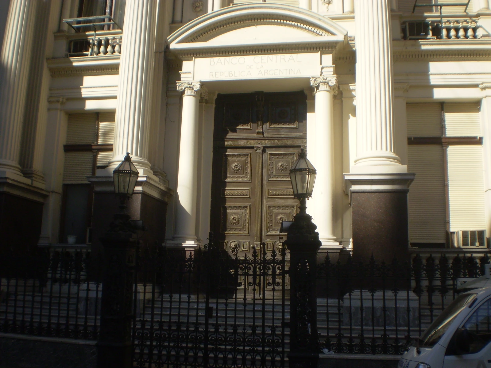 Central Bank of the Argentine Republic building, exterior, ornate door, columns, iron fence.
