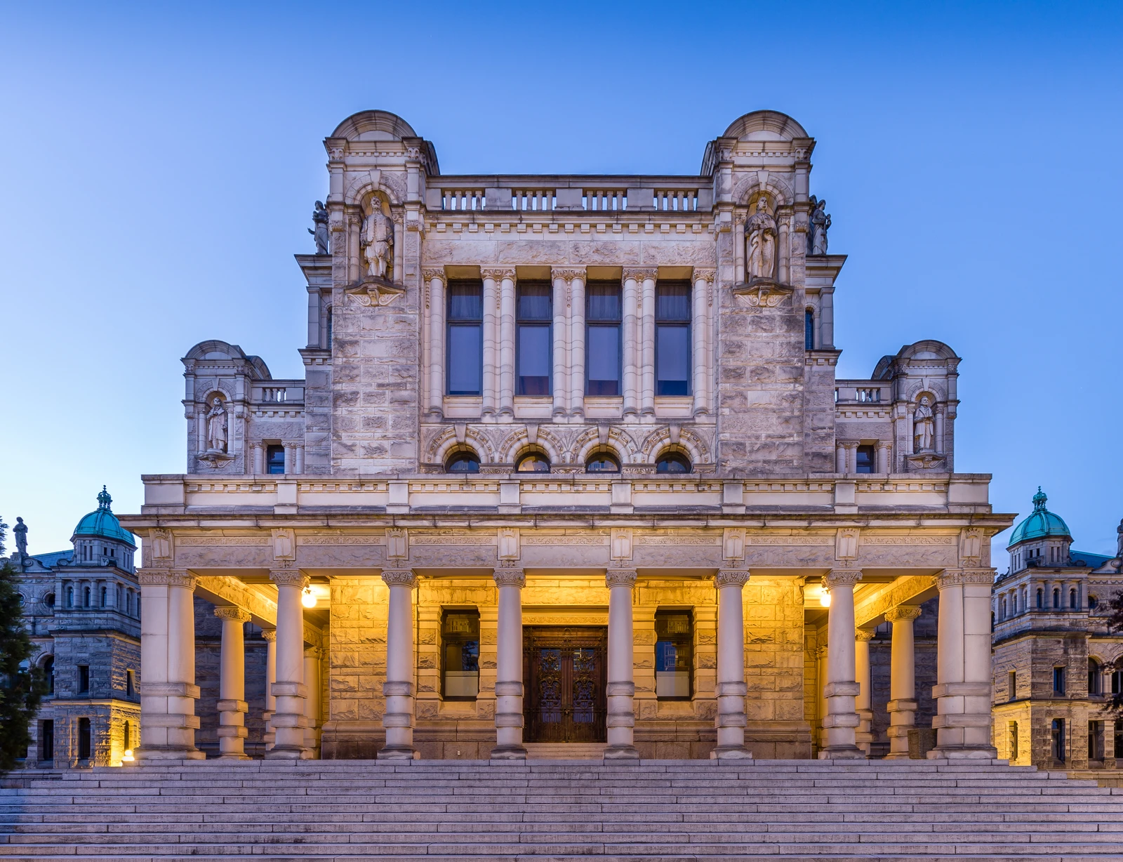 The British Columbia Parliament Building in Victoria at dusk with blue sky.