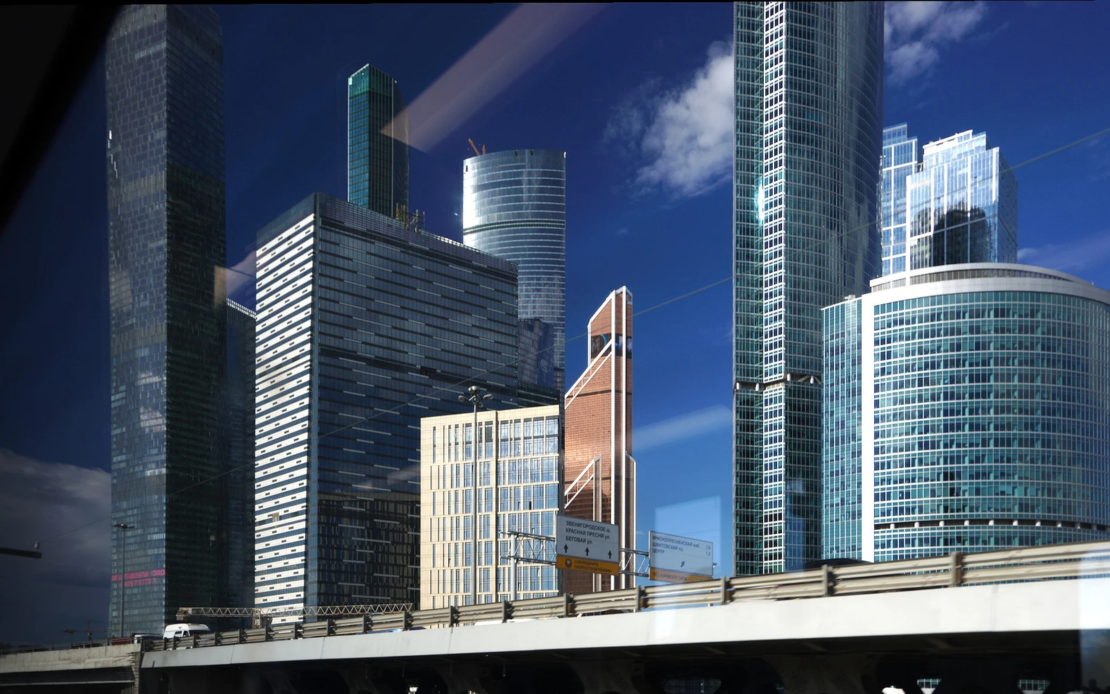Skyscrapers of the Moscow International Business Center rise above a highway overpass.