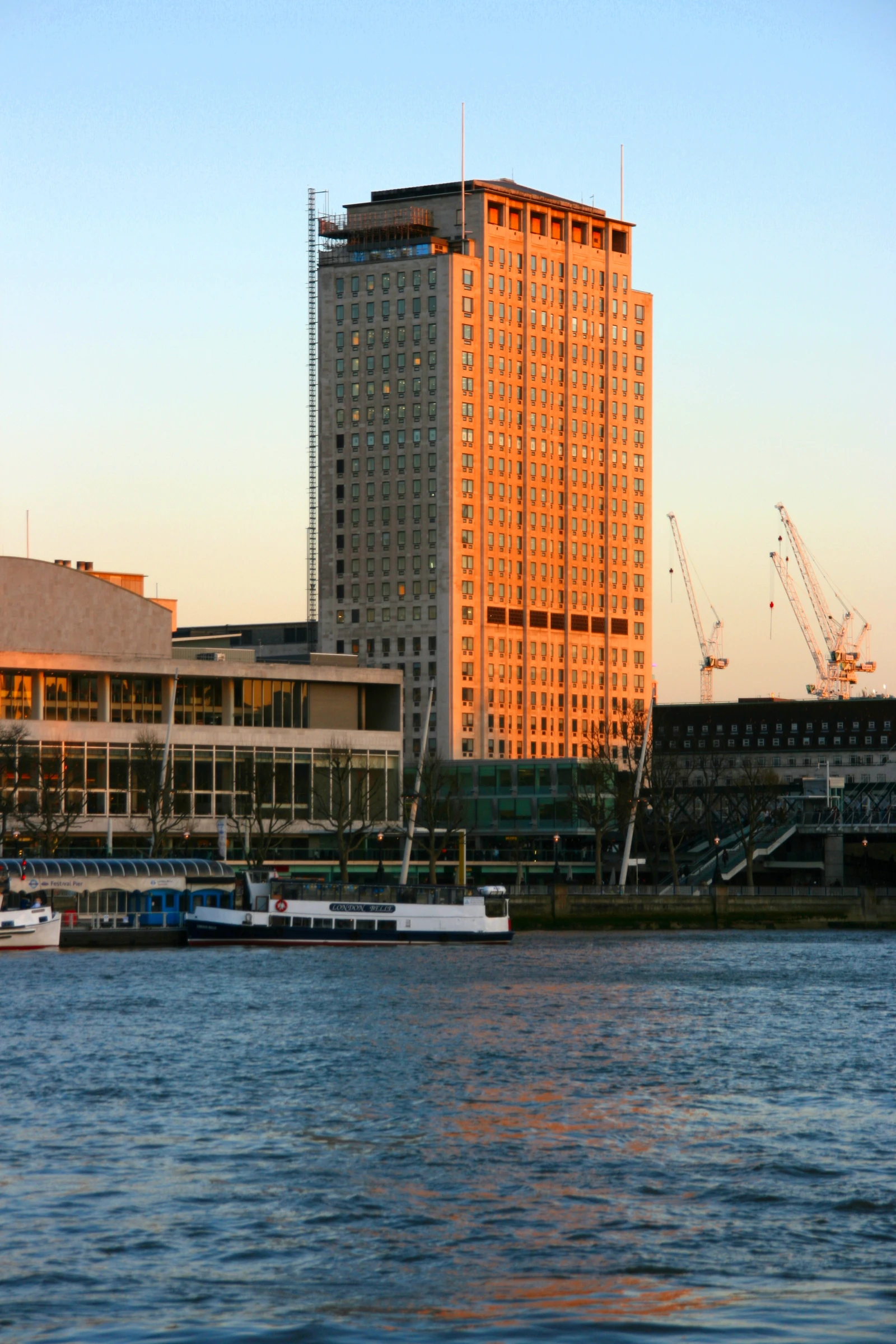 Shell Centre, global headquarters of Shell plc, reflected in the River Thames, London.
