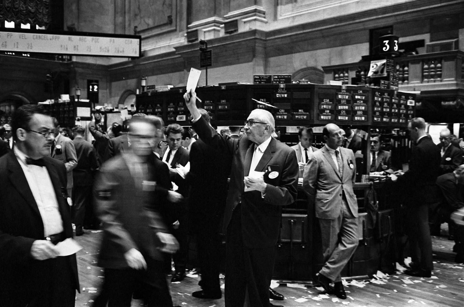 Men in suits on the bustling trading floor of the New York Stock Exchange.