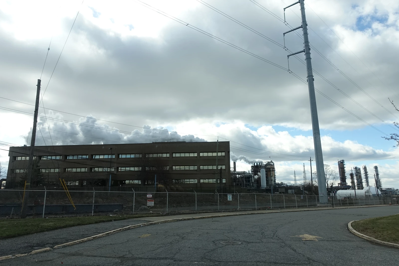 Bayway Refinery industrial buildings and towering structures under a cloudy sky.