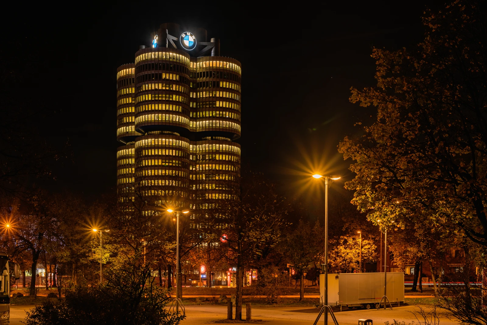 BMW Tower, also known as BMW Headquarters, brightly illuminated at night in Munich, Germany.