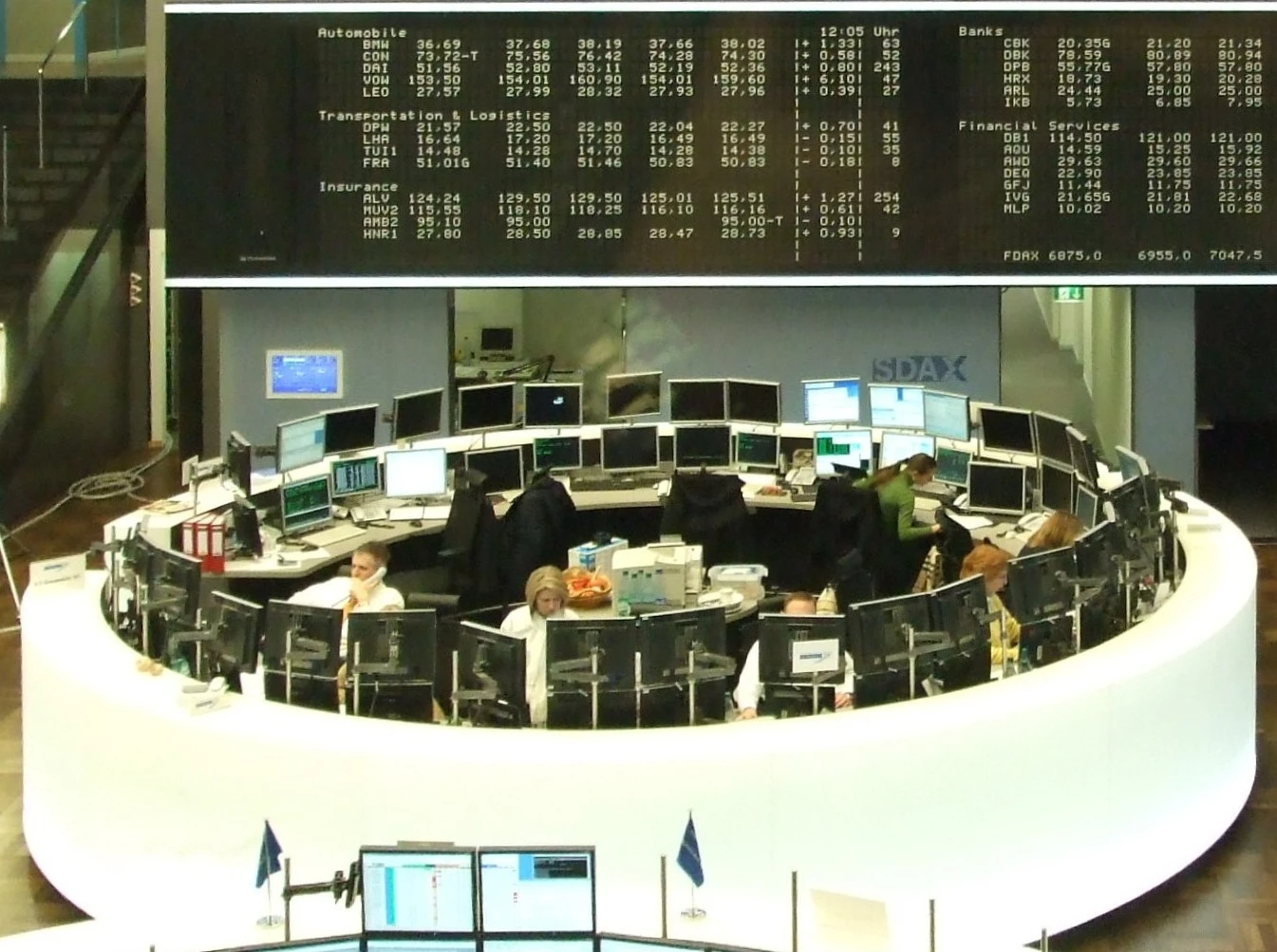 Traders monitor multiple computer screens at a stock exchange trading desk.