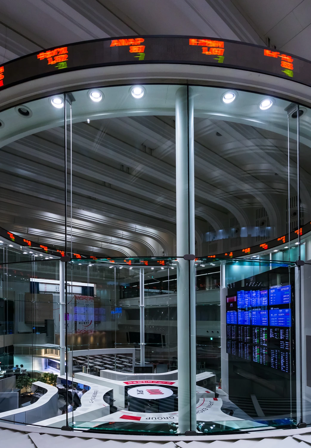 Interior of the Tokyo Stock Exchange main trading room with glass walls and information screens.