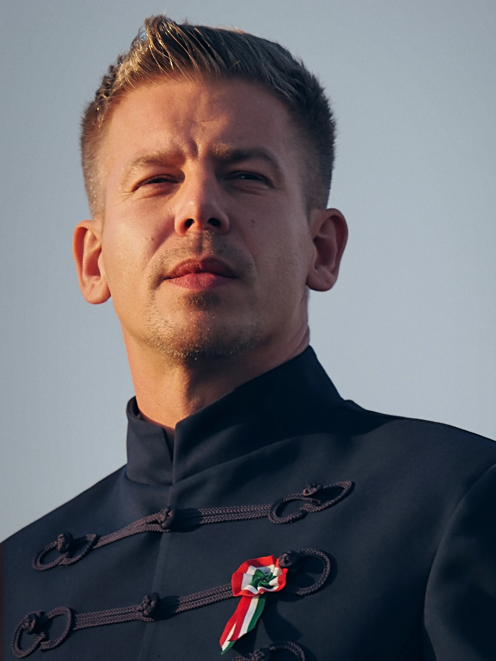 Péter Magyar, Hungarian politician, wearing a dark traditional tunic outdoors.