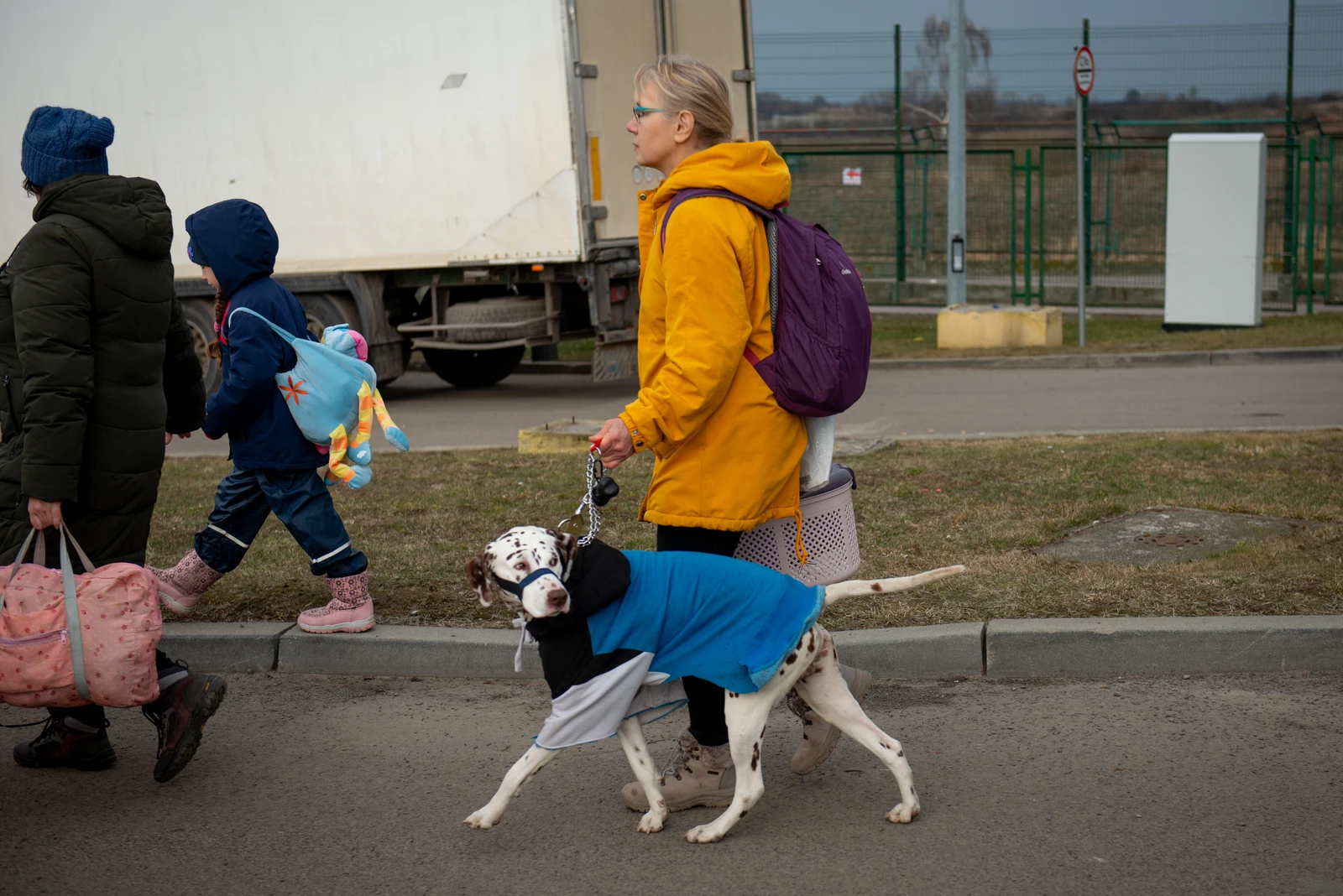 People with a dog walk on a street in the border region between Poland and Ukraine.