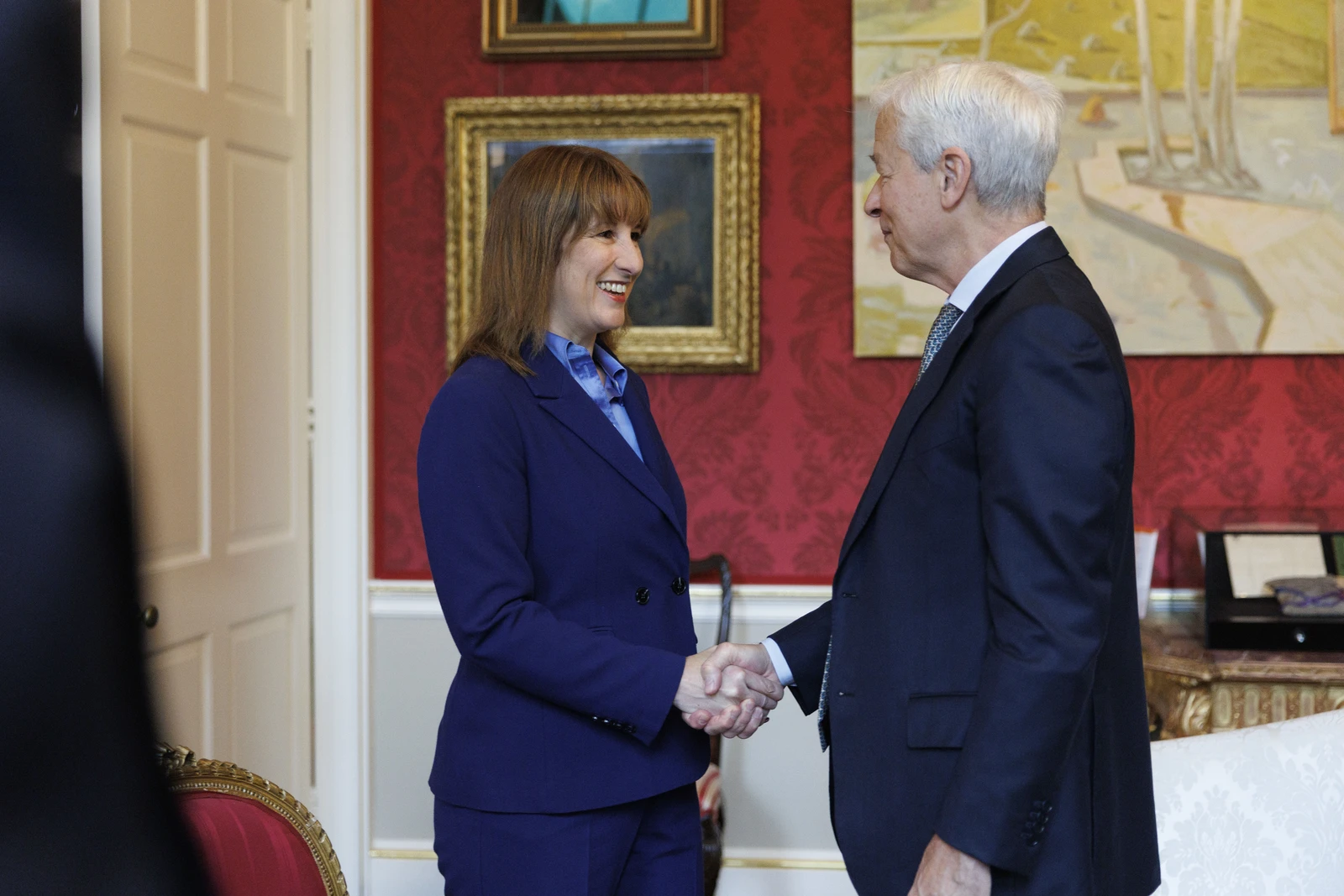 Rachel Reeves, UK Chancellor, shakes hands with Jamie Dimon, JPMorgan CEO.