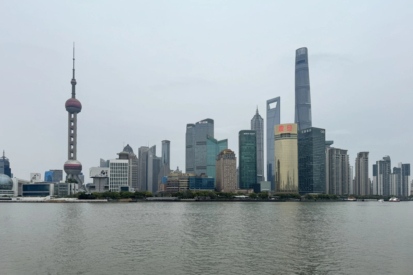Shanghai skyline featuring the Oriental Pearl TV Tower and modern skyscrapers across the river.