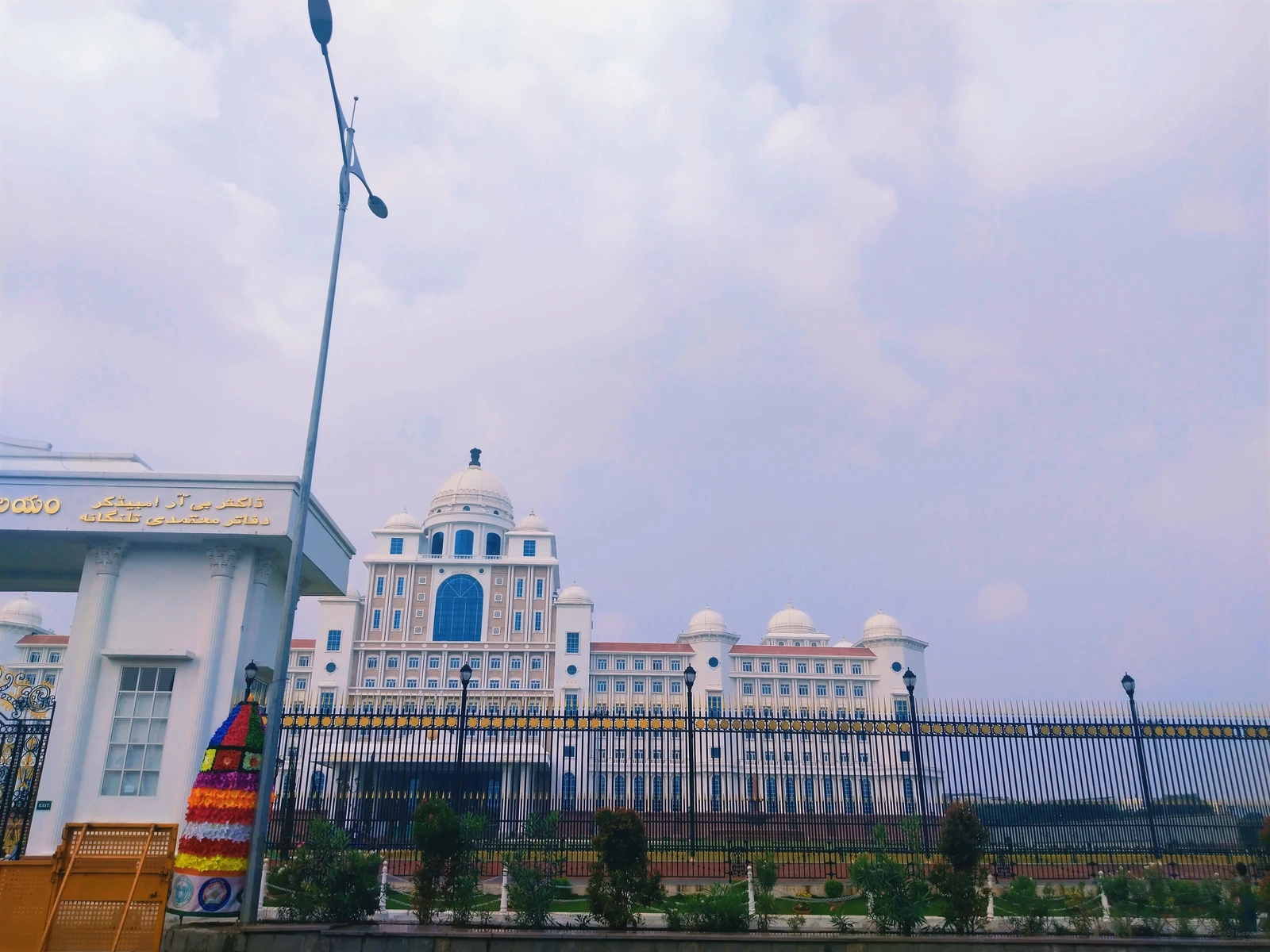 Exterior view of the Telangana Secretariat building under a cloudy sky.